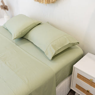 Green gumleaf bamboo sheets on mattress with white sideboard