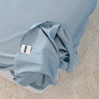 sienna living logo tag showing on the underside of the corner of a blue fitted sheet