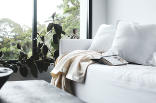 bright white room with a white couch with a ivory woolen blanket