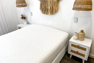 white mattress protector in a white room with white and wooden furnishing